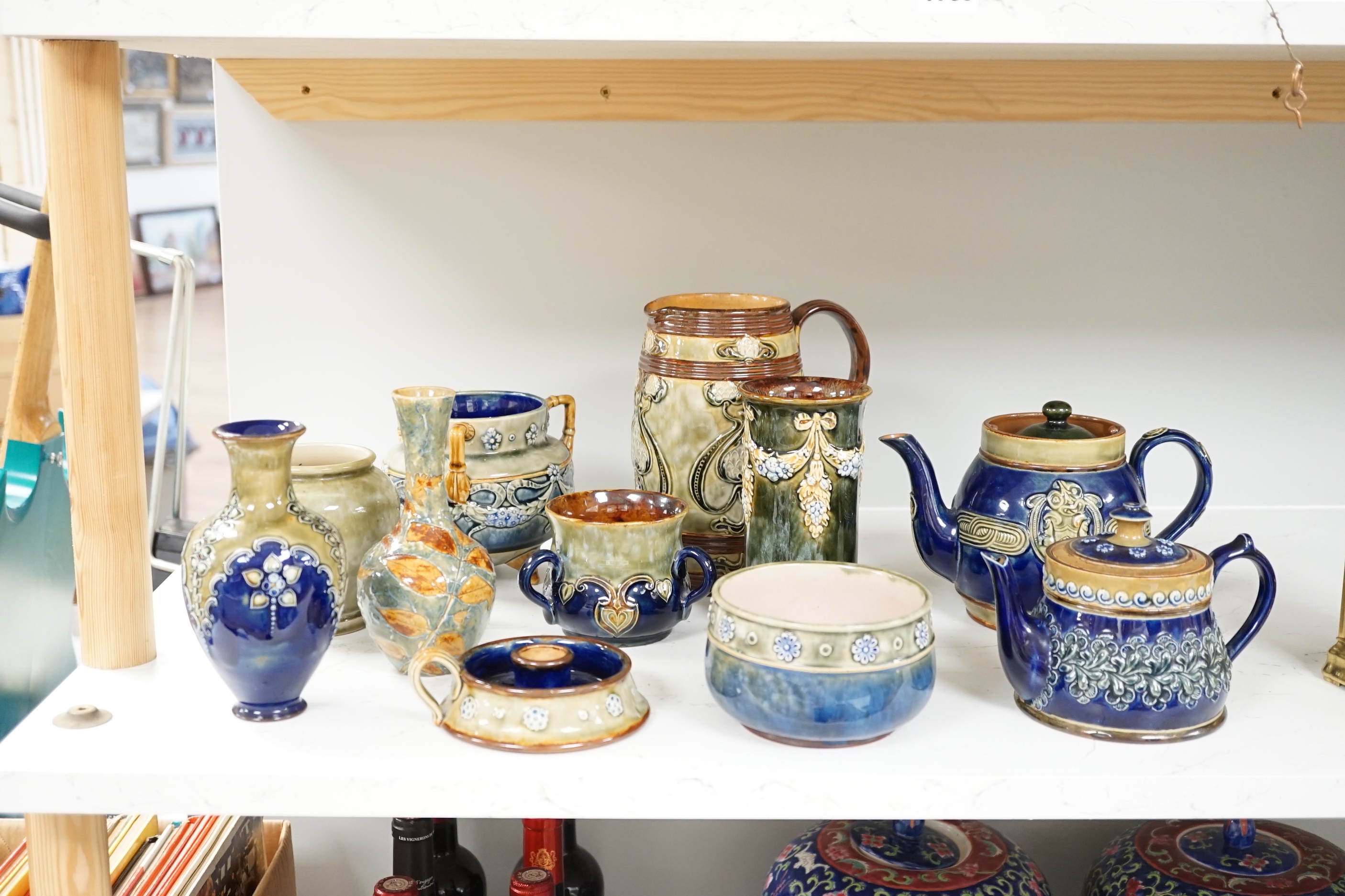 A collection of blue glazed Doulton stoneware, including vases teapots, bowl, jug and a candle holder (11)